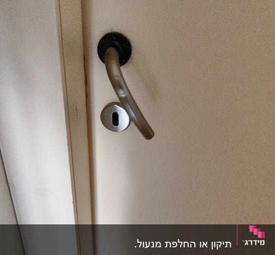 ידית דלת ומנעול מתכת על דלת לבנה